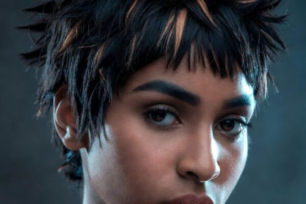 A stunning collection of 22 bold and beautiful 90s bixie haircut ideas for Black women showcasing a confident Black woman with a perfectly styled tapered curly bixie featuring defined natural curl texture clean tapered sides and soft side-swept fringe representing the full range of low-maintenance and head-turning 90s golden era inspired bixie styles from finger waves and spiky highlights to bleached blonde tops crimped texture and iconic voluminous side sweeps.
